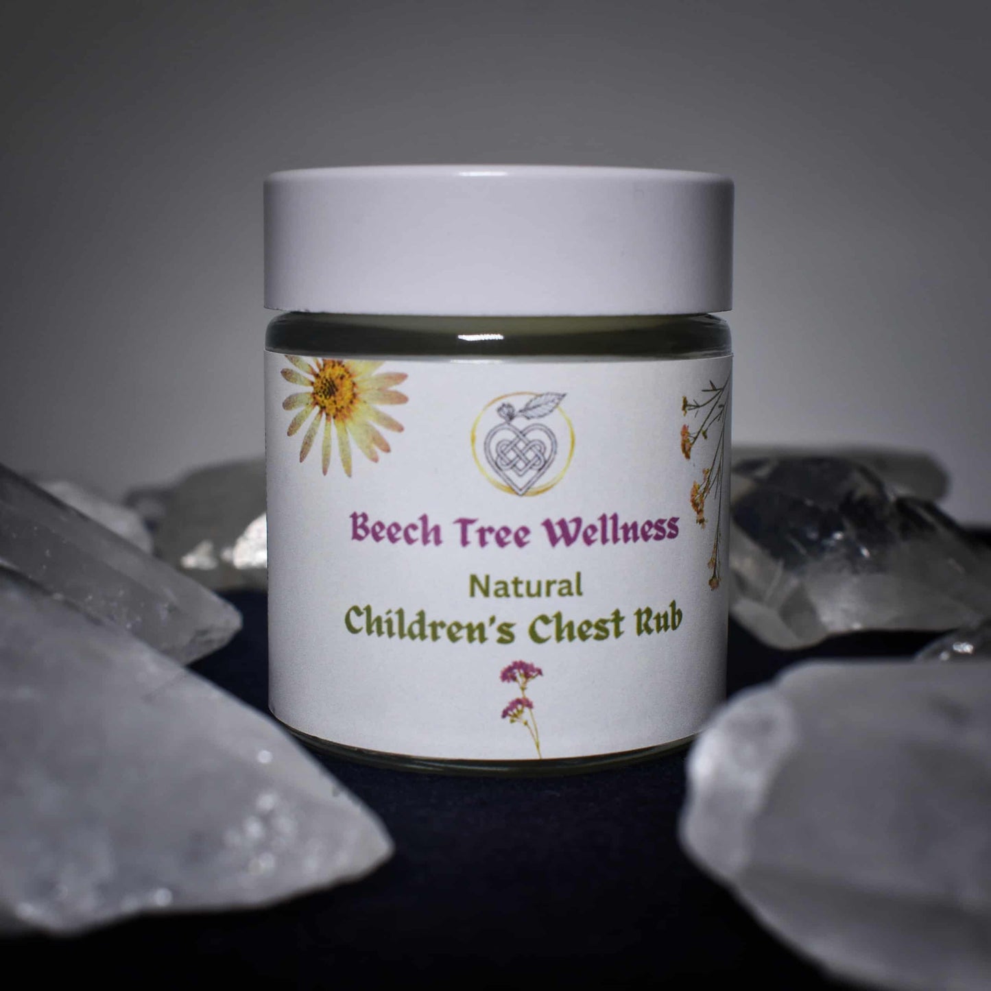 Jar of Beech Tree Wellness Natural Children's Chest Rub with a floral label on a dark background.